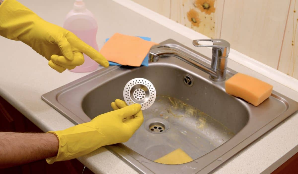 Person pointing to a sink strainer