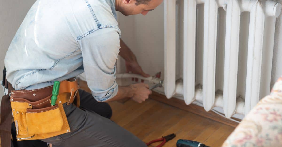 leaking radiator - plumber tightening pipe