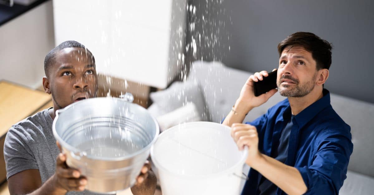 Two Men Holding Buckets due to Roof Leak