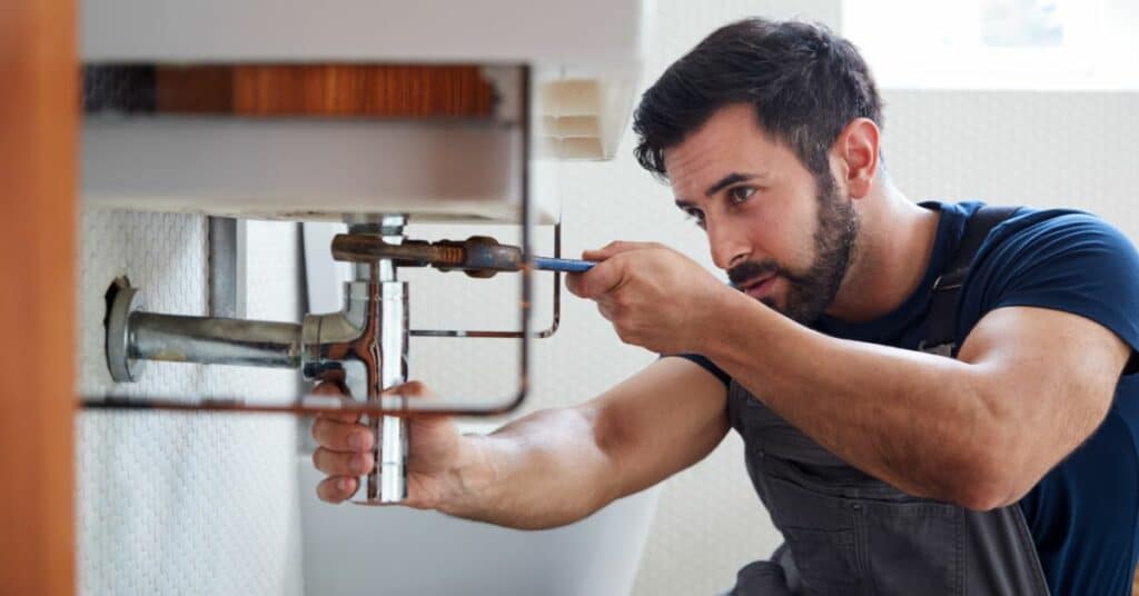 General plumber fixing a bathroom sink