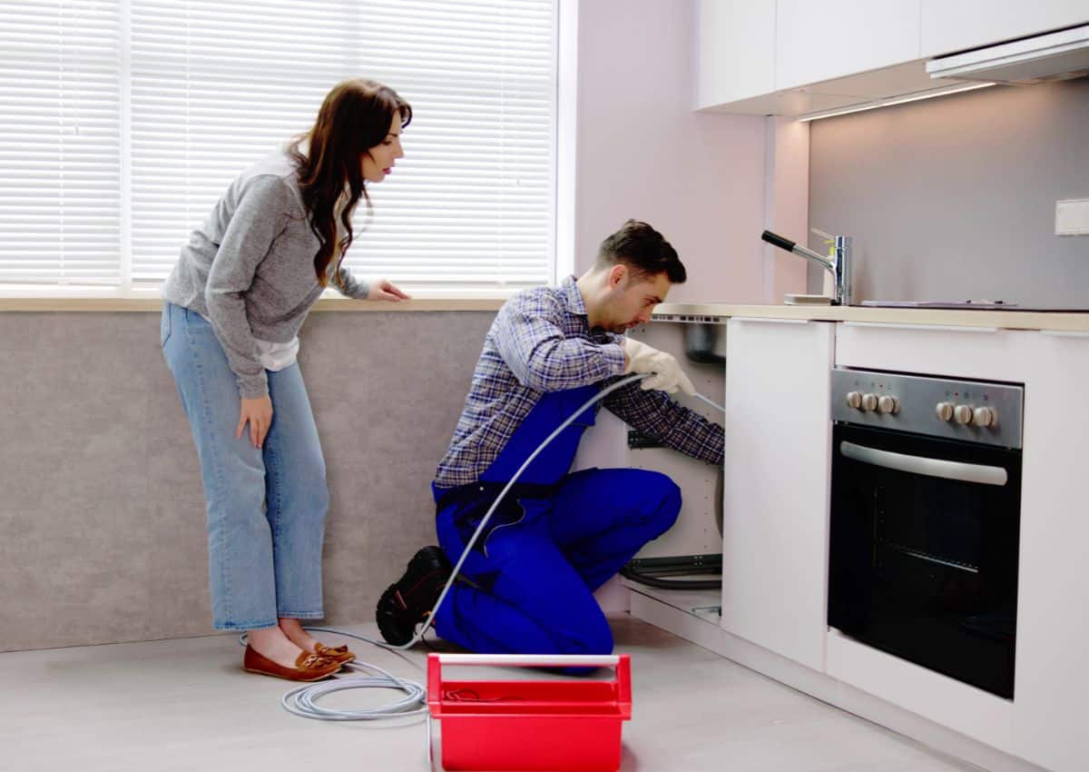 Plumber unblocking drain