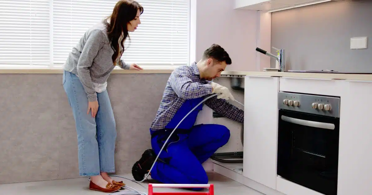 Plumber assisting a client with a kitchen sink issue
