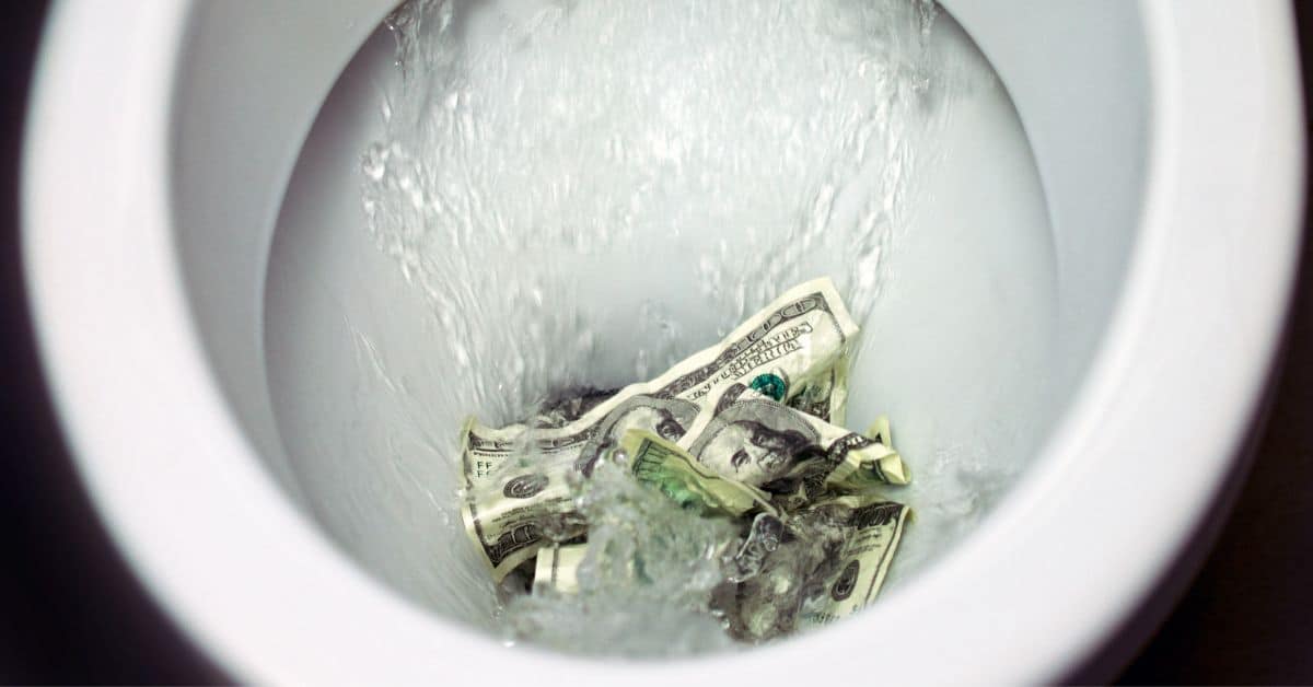 Money being flushed down the toilet