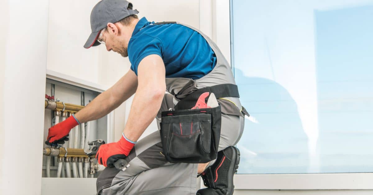 commercial heating engineers - plumber fixing underfloor heating