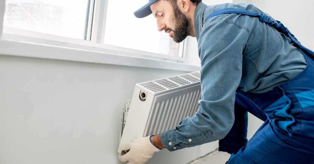 Plumber installing a new radiator