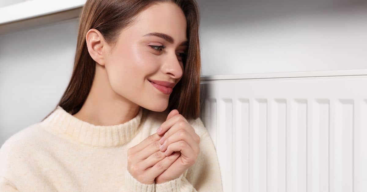 Lady keeping warm with her wall heater