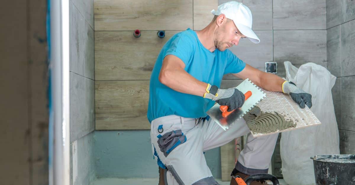 Man putting cement on tiles