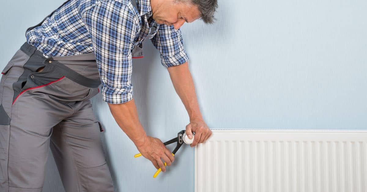 power flush cost - Plumber working on a radiator