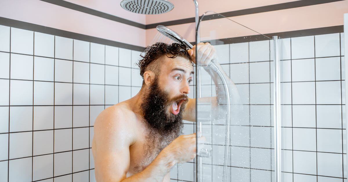 Man in shower freaking out due to water turning cold