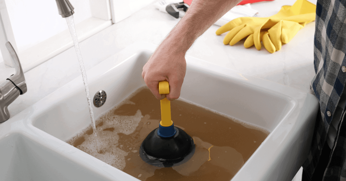 Homeowner plunging blocked kitchen sink 