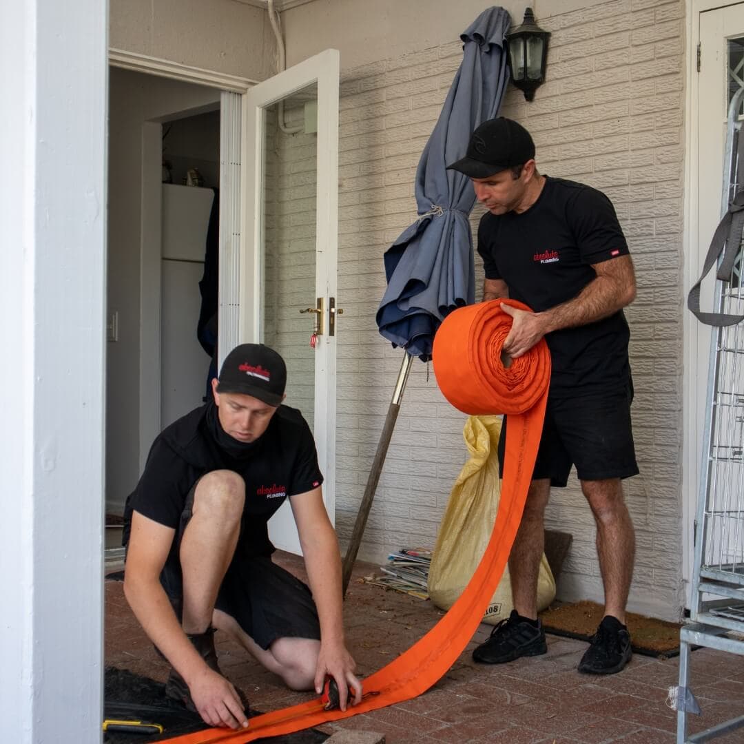 Absolute Plumbing Team Members laying our drain lining equipment