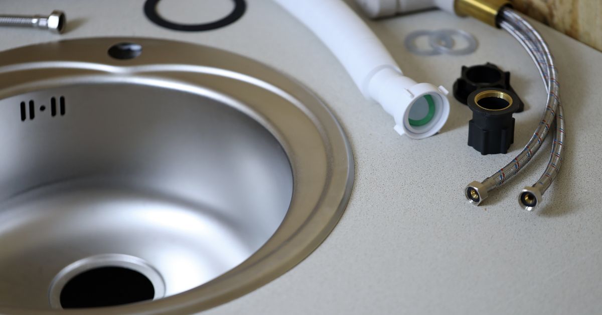 A tap being installed in a kitchen sink