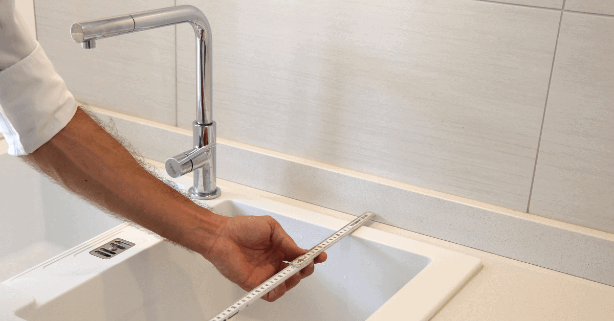 Measuring a kitchen sink before fitting it into a worktop 