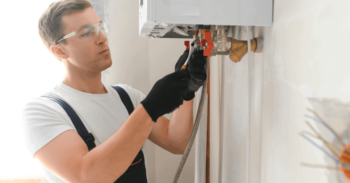 Engineer inspecting boiler and pipework for safety 
